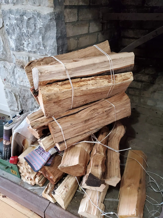 Split firewood bundles arranged beside an unlit fireplace.